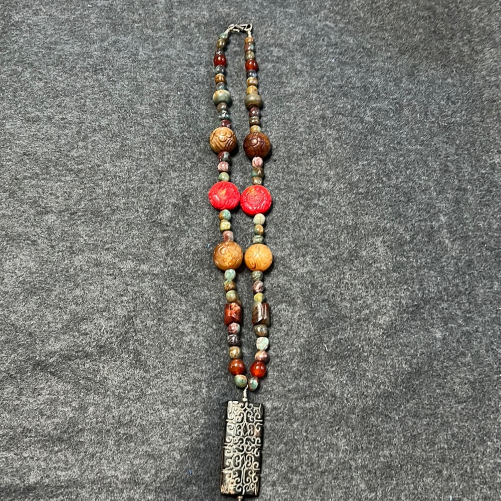 Stone and carved bead necklace. 2” inch dark brown carved statement bead.